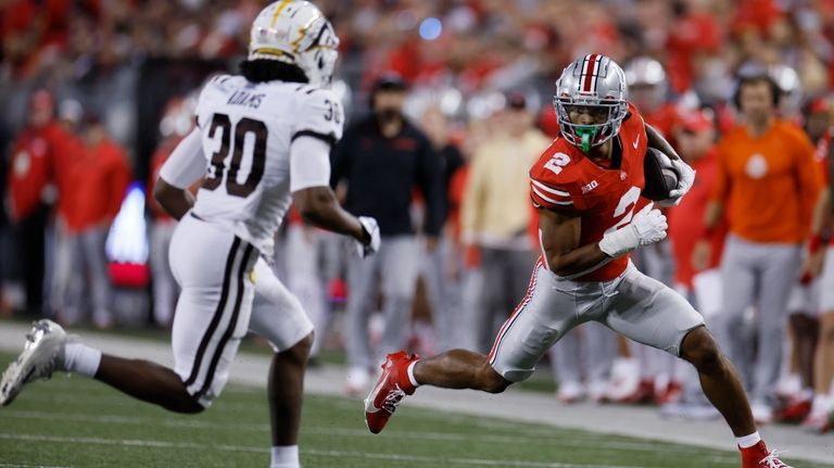 Ohio State receiver Emeka Egbuka, right, runs against Western Michigan...