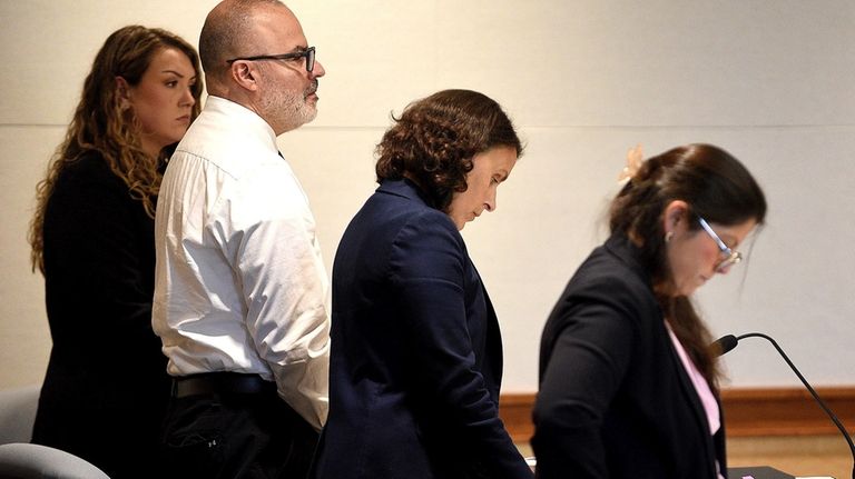 Victor Malavet, center, stands with his lawyers as the court...