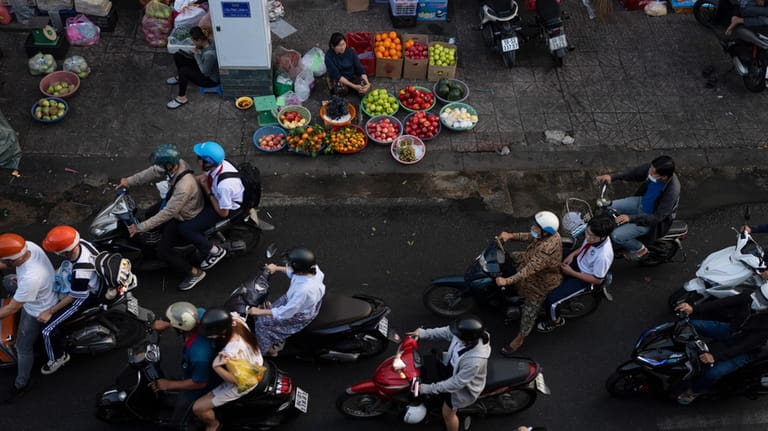 Commuters move past street vendors during morning rush hour in...