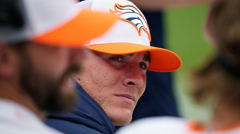 Denver Broncos quarterback Bo Nix sits on the team bench...