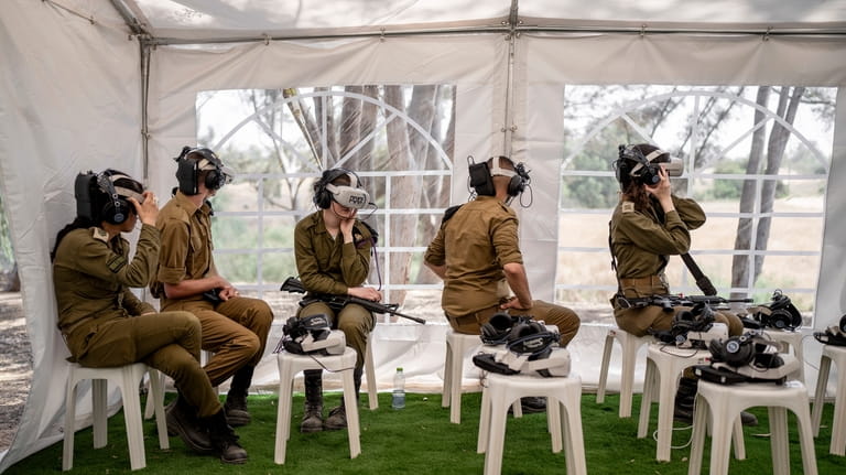 Israeli soldiers watch a virtual tour of the destruction of...