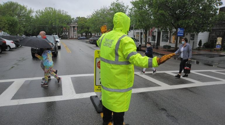 People cross the street on Main Street in Southampton on...