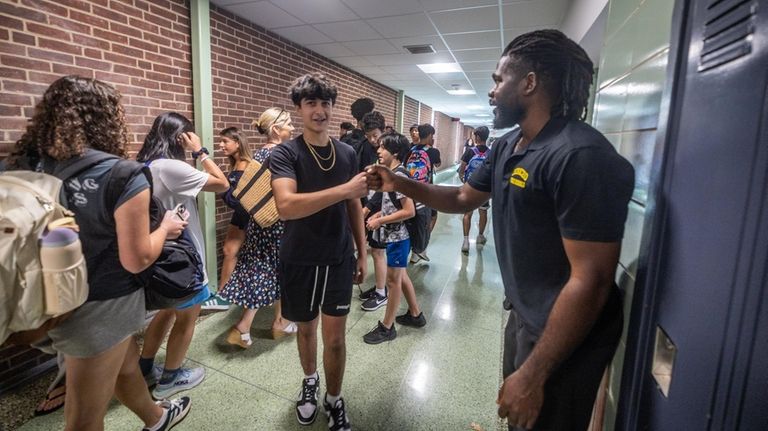 Security guard Julius Opa greets students on their first day back at...