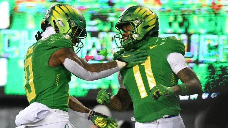 Oregon running back Bucky Irving (0) celebrates wide receiver Troy...