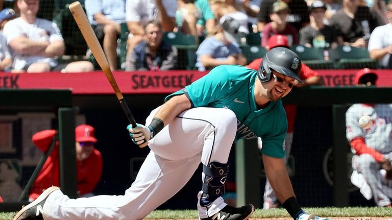 Seattle Mariners catcher Cal Raleigh takes a hard spin on...