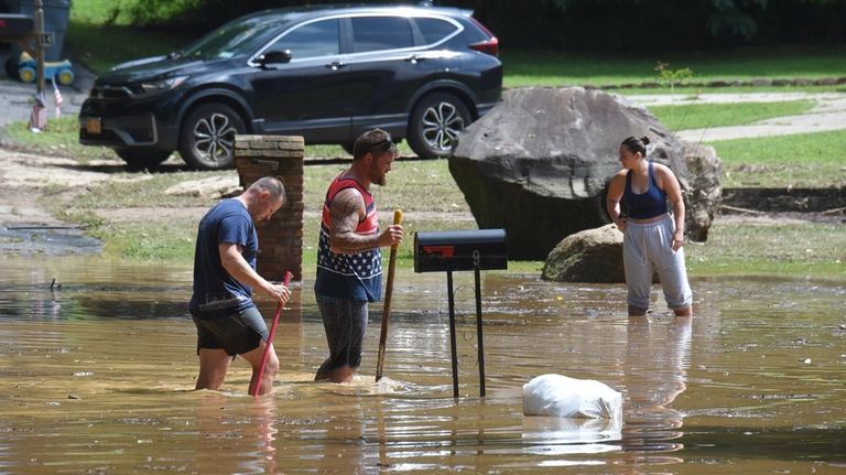 People try to unclog a drain on Secnd Avenue in...