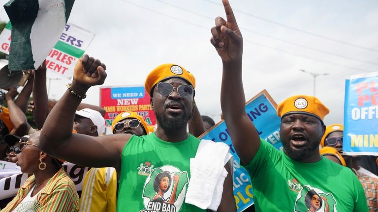 People gather to protest over economic hardship, on a street...