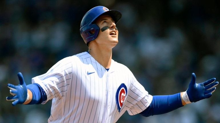 The Cubs' Anthony Rizzo celebrates at third base after hitting...