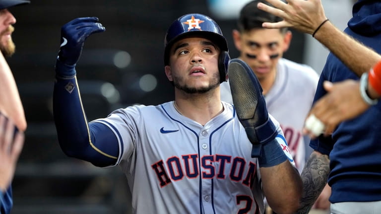 Houston Astros' Yainer Diaz is greeted in the dugout after...