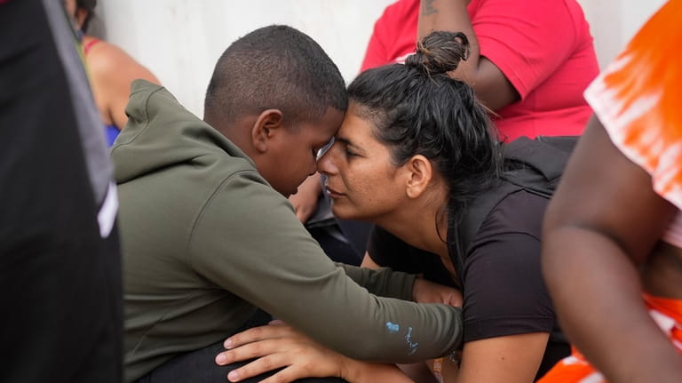 Venezuelan migrant Nelsy Zavala, right, embraces fellow Venezuelan migrant Yeikel...