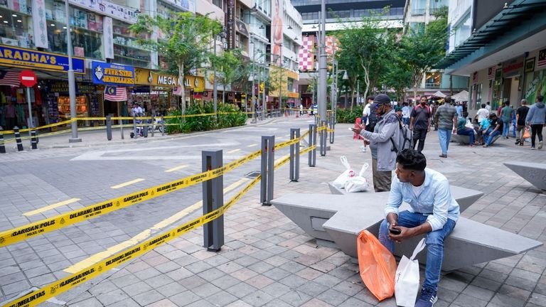 People sit next to a closed road after another deep...