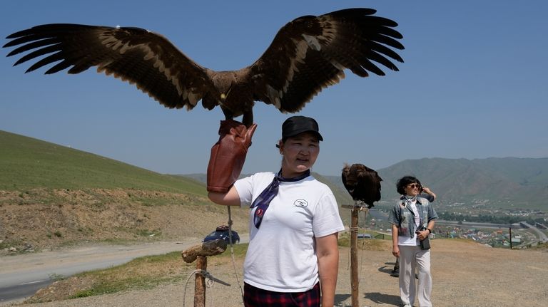 A vendor holds up an eagle as the waits for...