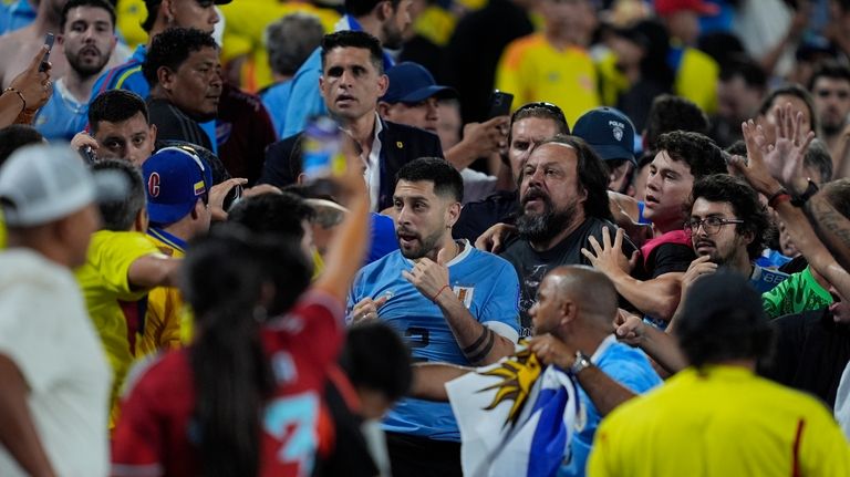 Uruguay's Jose Gimenez, center, argues with fans at the end...