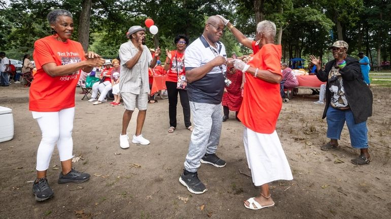 Leon Payton and Maryland Fritz, center, dance during the annual Amityville...