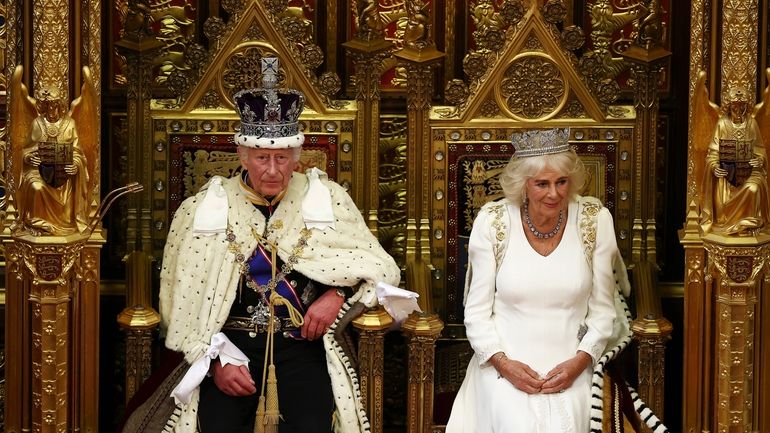 Britain's King Charles III, wearing the Imperial State Crown and...