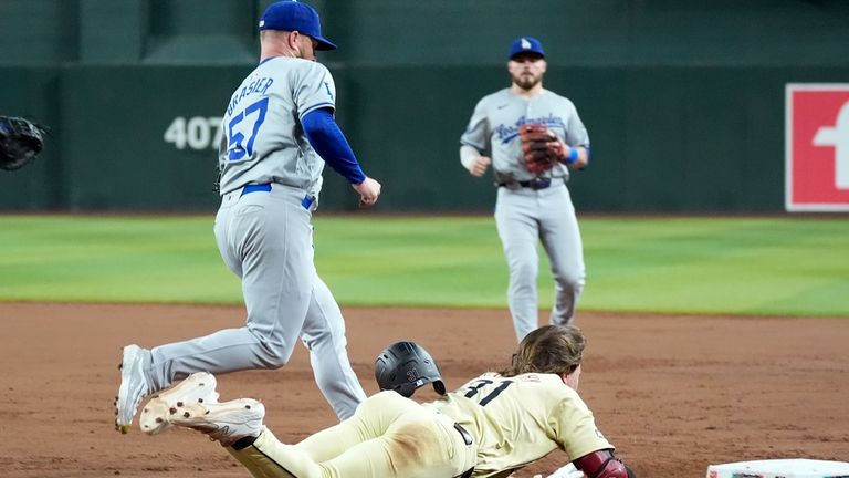 Arizona Diamondbacks' Jake McCarthy, right, beats out an infield single...