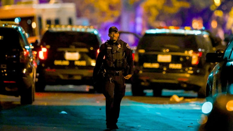 Oakland police officers respond to a multiple shooting during a...