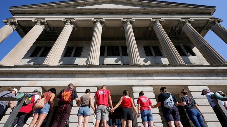 Demonstrators hold hands and encircle the State Capitol in prayer...