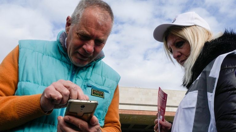 A tourists is checked by a steward for QR code...