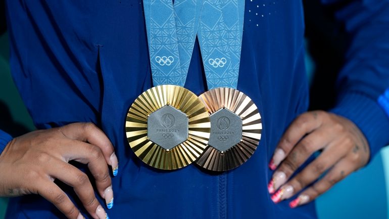 Jordan Chiles, of the United States, holds up her medals...