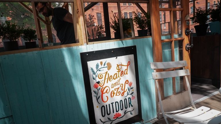 A customer takes a seat in the outdoor dining shed...