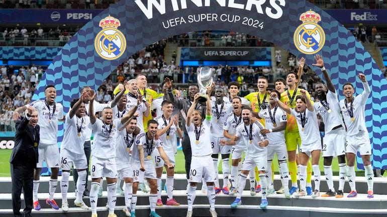 Real Madrid's Luka Modric lifts the trophy after winning the...