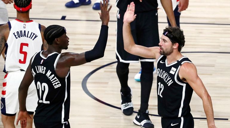 Brooklyn Nets guard Caris LeVert, left, and forward Joe Harris high-five...