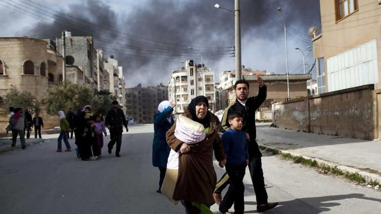 A family escapes from fierce fighting between Free Syrian Army...
