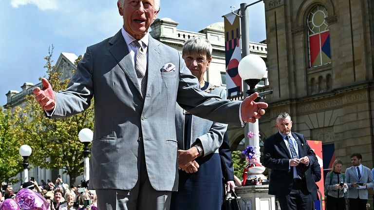 Britain's King Charles III looks at the tributes outside Southport...