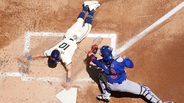 Milwaukee Brewers' Sal Frelick slides safely past Chicago Cubs catcher...