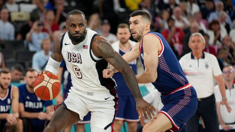 United States' LeBron James (6) drives past Ognjen Dobric (13),...