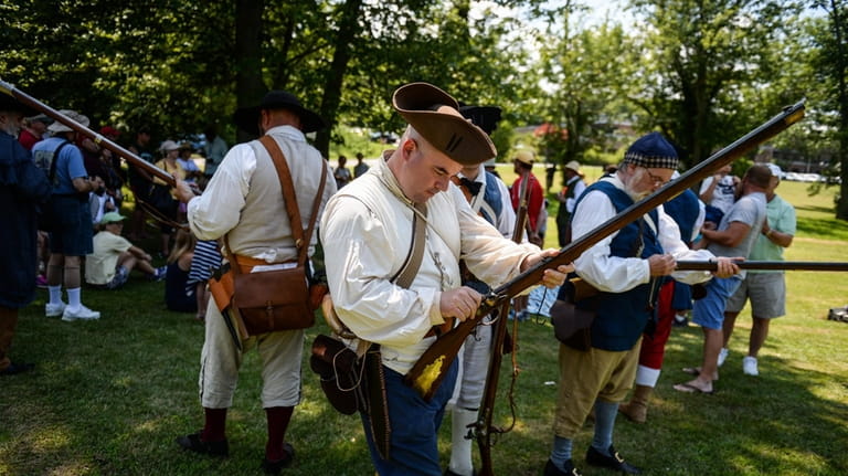 Colonial reenactors load their muskets at the Colonial Arsenal Museum...