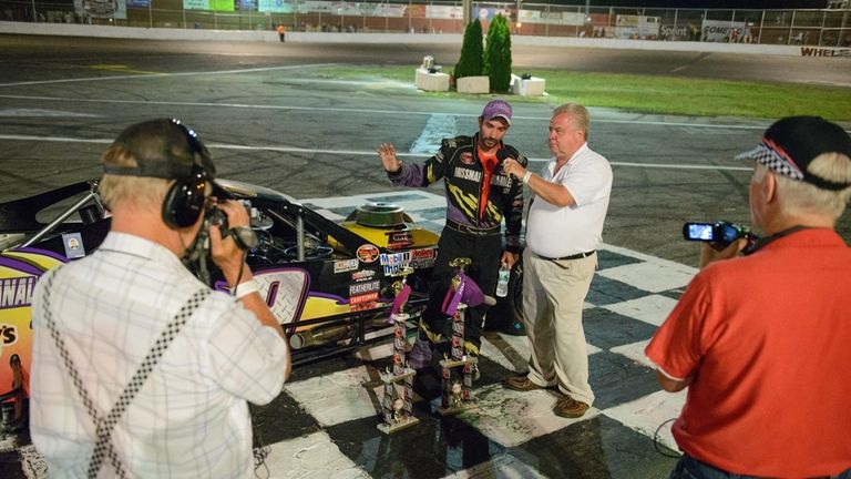 Driver Tom Rogers Jr. of Riverhead talks to race commentator...