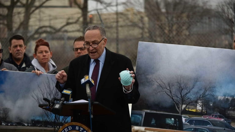 Sen.Charles Schumer speaks holding an air filtration mask in his...