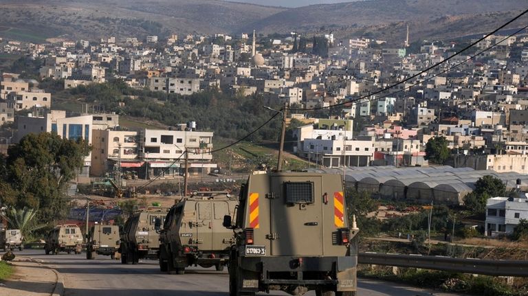 A convoy of Israeli army vehicles is seen during a...