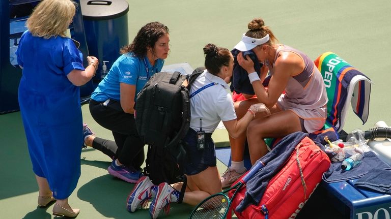 Beatriz Haddad Maia, of Brazil, is checked by medical personnel...