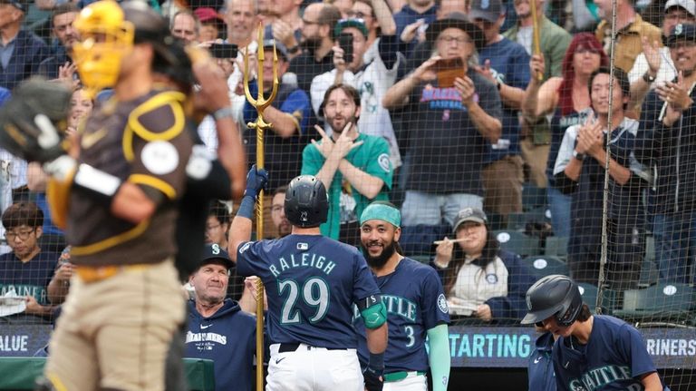 Seattle Mariners' Cal Raleigh (29) celebrates with manager Dan Wilson,...