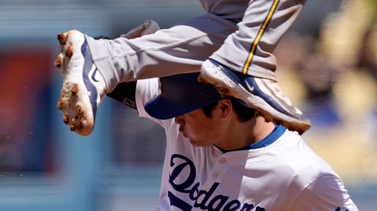 Los Angeles Dodgers' Shohei Ohtani, below, slides into second in...