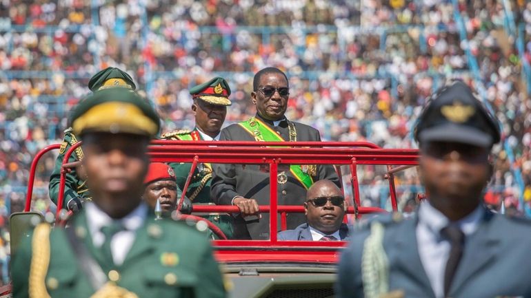 Zimbabwean President Emmerson Mnangagwa, centre, inspects a guard of honour...