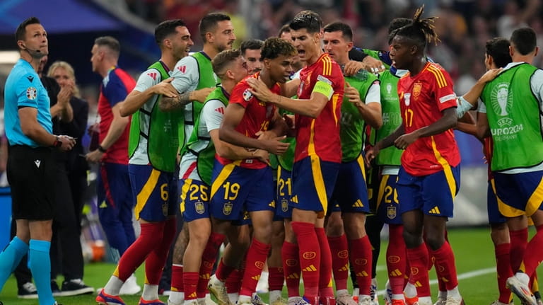 Spain's Lamine Yamal celebrates with his teammate after scoring his...