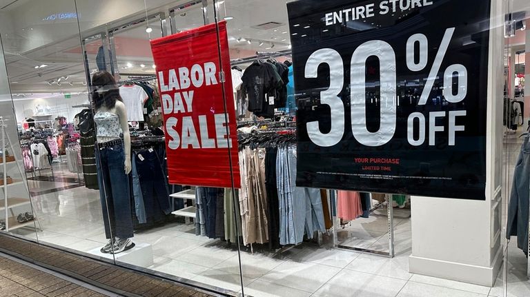 Signs announcing a Labor Day sale hang in the window...