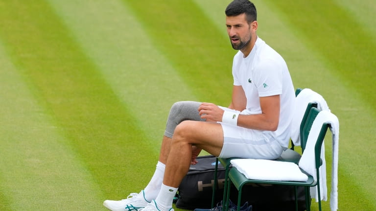 Novak Djokovic of Serbia sits in his chair during a...