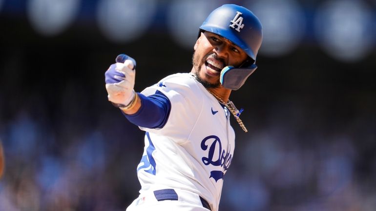 Los Angeles Dodgers' Mookie Betts reacts after hitting a home...