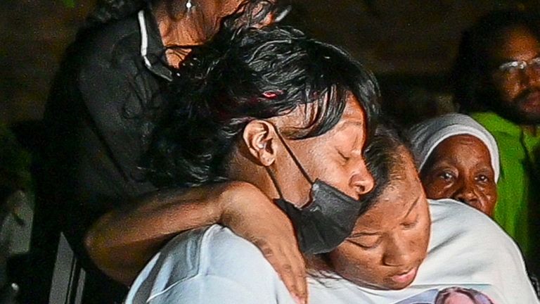 Seikeya Jones' mother, Yolanda Terrell, in mask, hugs daughter Dijonzhane Johnson...