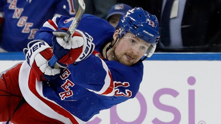 Alexis Lafreniere #13 of the Rangers shoots the puck against the Devils...