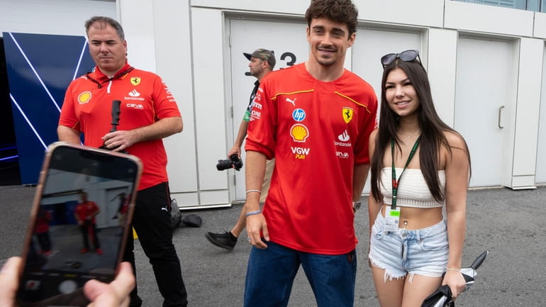 Ferrari driver Charles Leclerc poses for a photo with a...