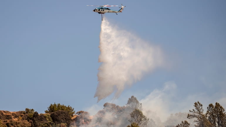 A Pacific Gas and Electric Company (PG&E) firefighting helicopter releases...