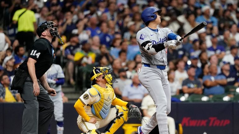 Los Angeles Dodgers' Shohei Ohtani, right, watches the ball after...