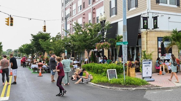 People dine and mill about along Main Street in Patchogue...