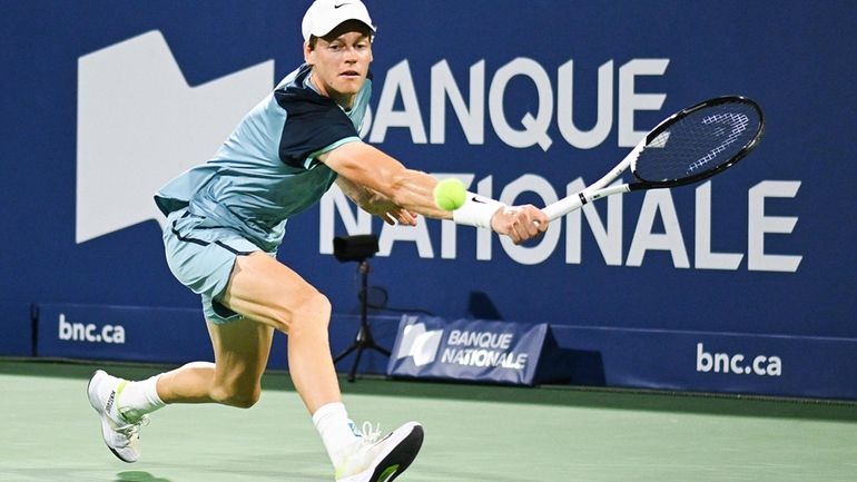 Jannik Sinner, of Italy, plays a shot to Andrey Rublev,...